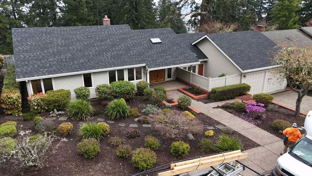 Modern suburban home with well-maintained landscaping and driveway, featuring vibrant flowers.