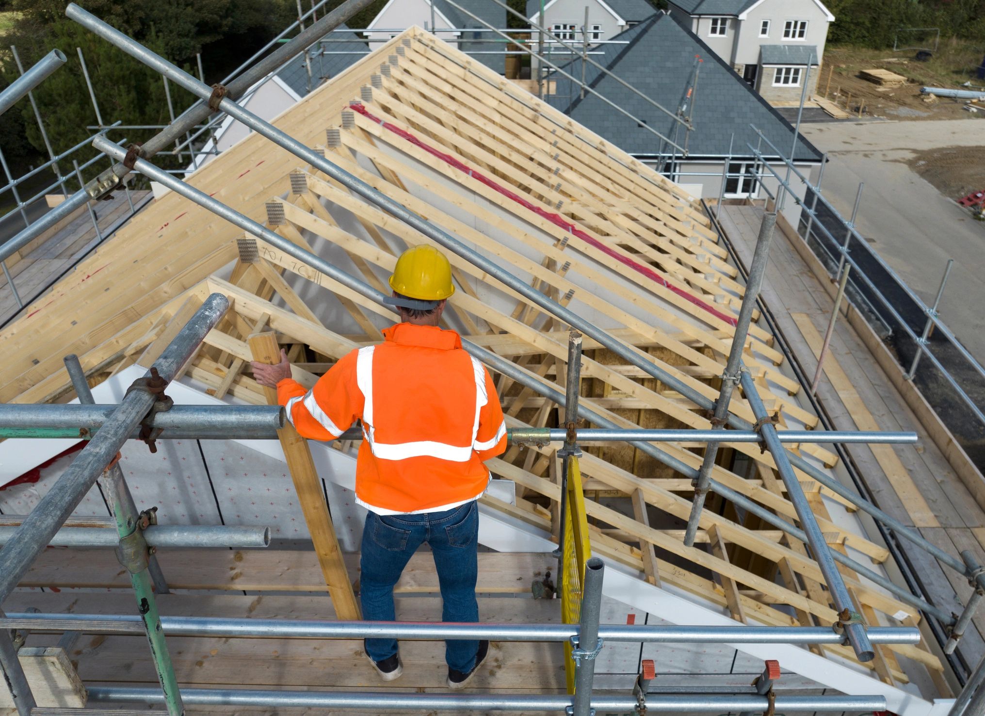 Roofing professional working on residential roof framing during an inspection