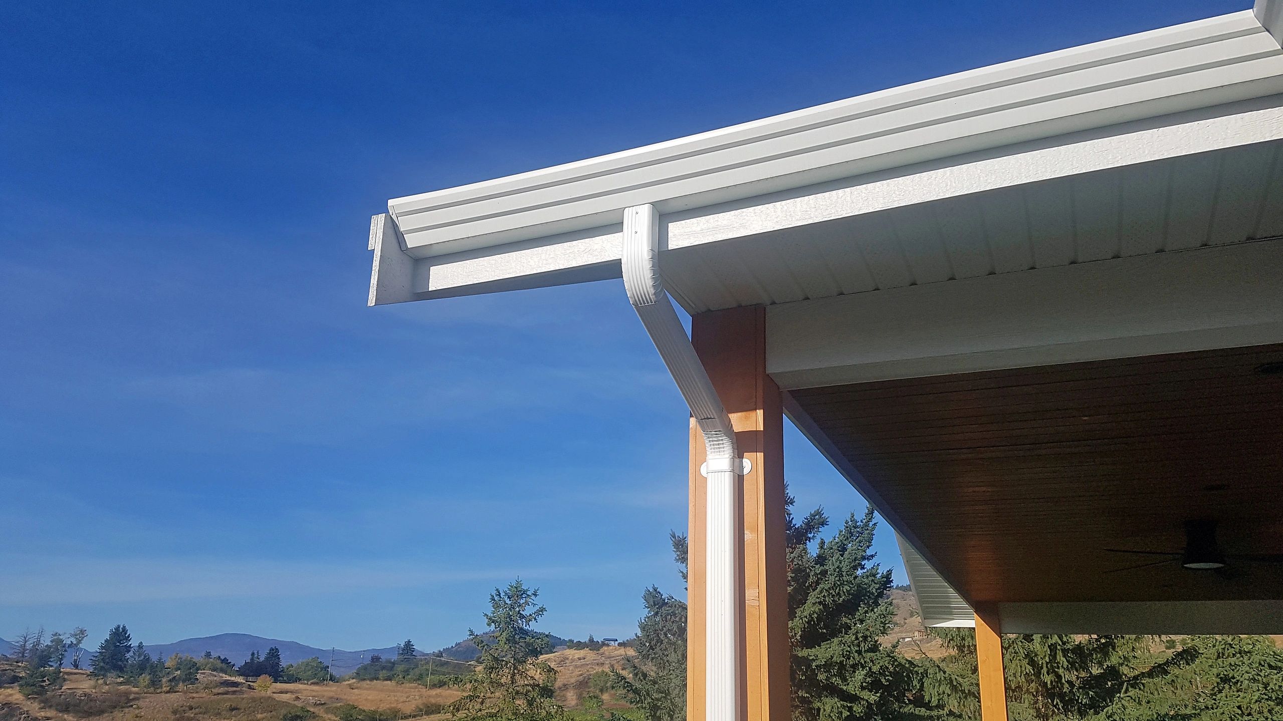 Close-up of residential gutters and downspout along roofline